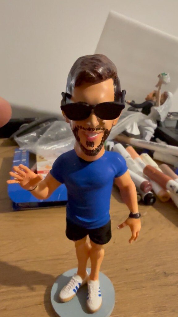 Personaliziran bobblehead junij 2026 — končni izdelek z gibajočo glavo, modro majico in sončnimi očali